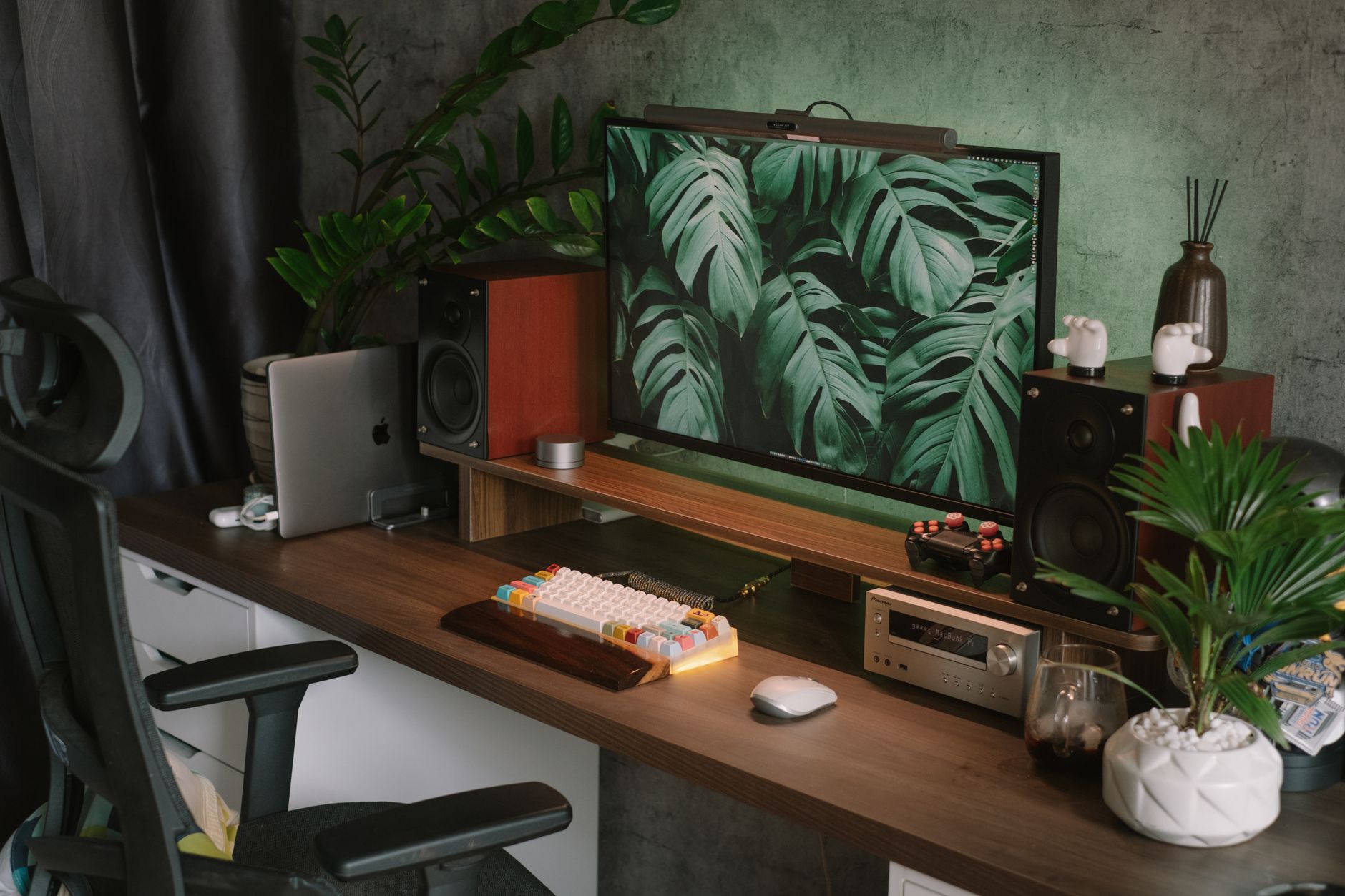 Bureau à domicile avec écran vintage, plantes et matériel moderne, ambiance studio de travail indépendant.