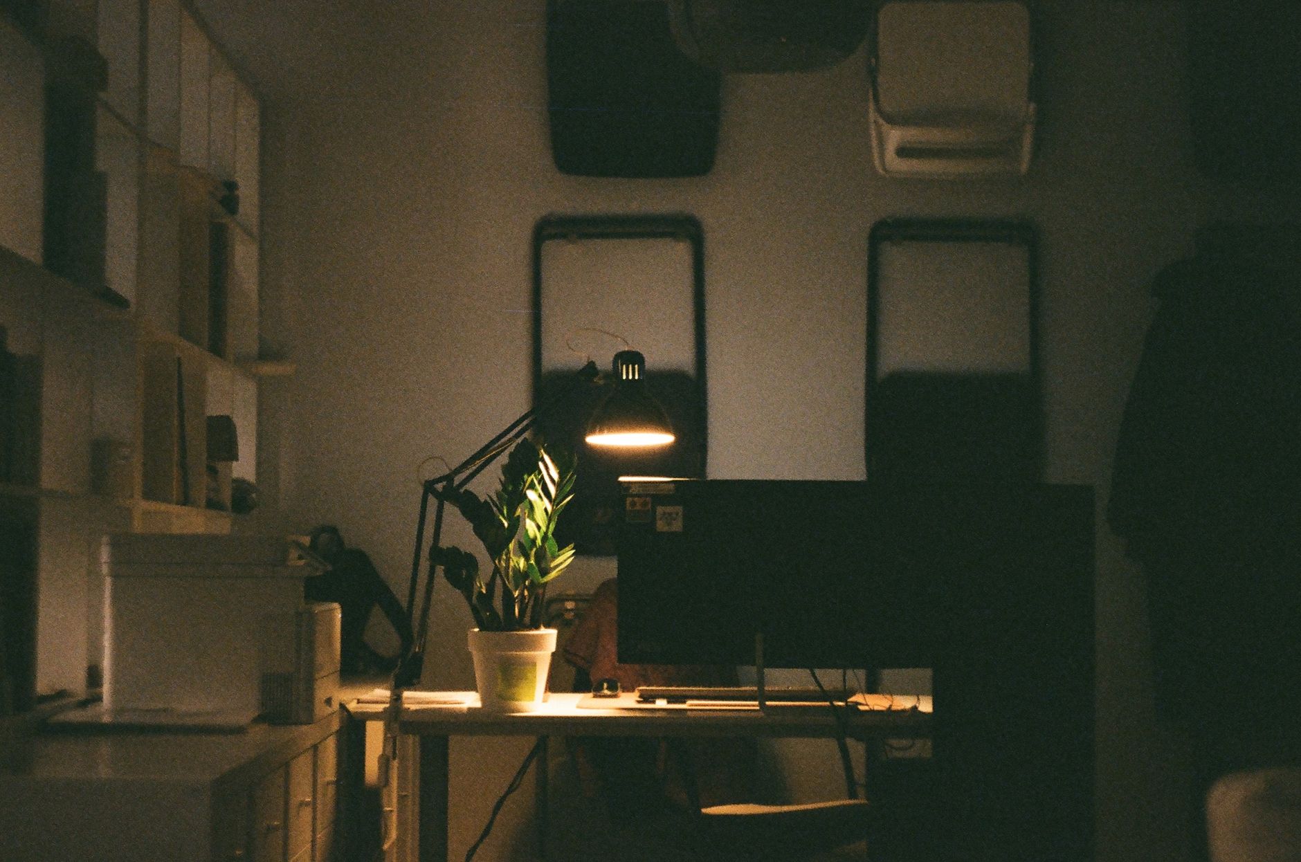 Bureau de travail sobre avec lampe et plante verte, ambiance concentrée pour un travail assisté par IA.